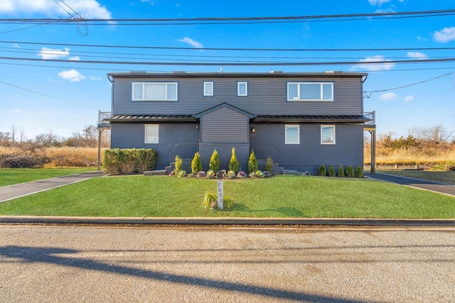 2850 Shore Rd, Seaford, NY 11783 - traditional home with brick siding, a front yard, a standing seam roof, and metal roof