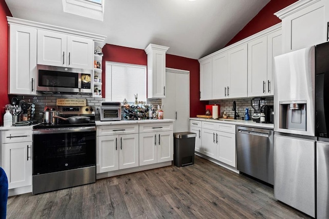 2850 Shore Rd, Seaford, NY 11783 - kitchen with appliances with stainless steel finishes, light countertops, decorative backsplash, white cabinetry, and lofted ceiling