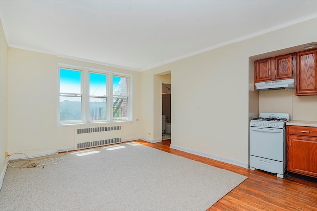 9430 Ridge Blvd Unit 6F, Brooklyn, NY 11209 - kitchen featuring radiator, white range with gas stovetop, under cabinet range hood, dark wood-type flooring, and brown cabinetry