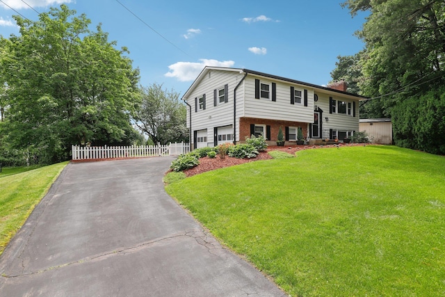 118 Standish Dr, Pearl River, NY 10965 - bi-level home with a chimney, asphalt driveway, brick siding, and an attached garage