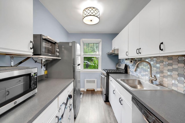 61 Columbus Ave Unit 1B, West Harrison, NY 10604 - kitchen with stainless steel appliances, radiator heating unit, backsplash, white cabinetry, and under cabinet range hood