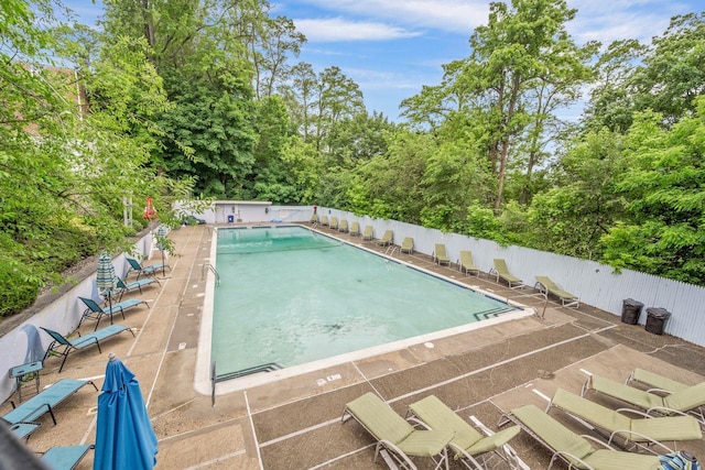 61 Columbus Ave Unit 1B, West Harrison, NY 10604 - community pool featuring a patio area and view of wooded area