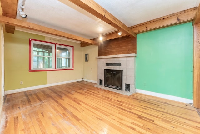 872-874 Rte 212, Saugerties, NY 12477 - unfurnished living room with a tile fireplace, beamed ceiling, hardwood / wood-style flooring, and baseboards