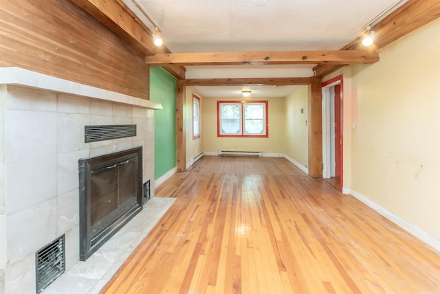872-874 Rte 212, Saugerties, NY 12477 - unfurnished living room with a tile fireplace, rail lighting, baseboard heating, light wood-style floors, and beamed ceiling