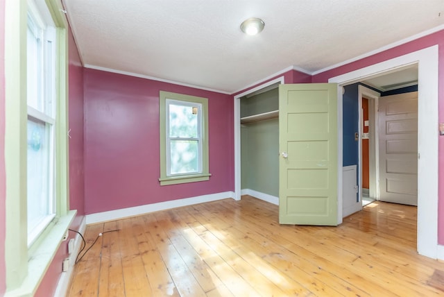 872-874 Rte 212, Saugerties, NY 12477 - unfurnished bedroom featuring baseboards, crown molding, a textured ceiling, light wood-style flooring, and a closet