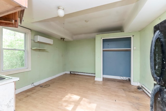 872-874 Rte 212, Saugerties, NY 12477 - unfurnished bedroom featuring baseboard heating, light wood-type flooring, an AC wall unit, baseboards, and a closet