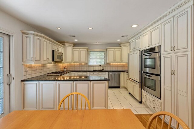 15 Dunmore Rd, New City, NY 10956 - kitchen featuring stainless steel appliances, cream cabinets, a peninsula, light tile patterned flooring, and recessed lighting