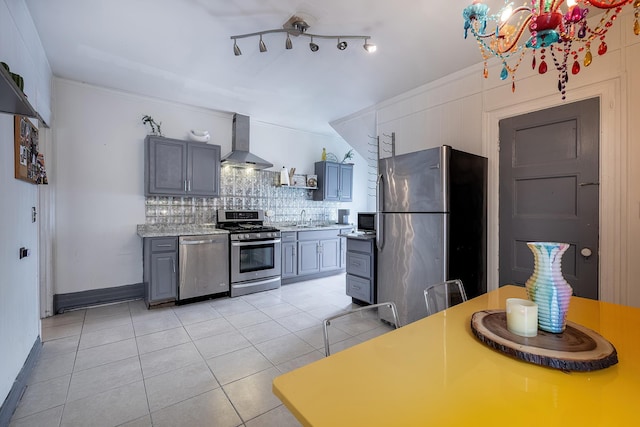 115 Primrose Ave, Mount Vernon, NY 10552 - kitchen with stainless steel appliances, wall chimney exhaust hood, tasteful backsplash, light tile patterned flooring, and a chandelier