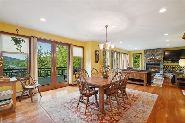 1034 Rte 292, Holmes, NY 12531 - dining space featuring french doors, a stone fireplace, light wood-type flooring, a chandelier, and recessed lighting