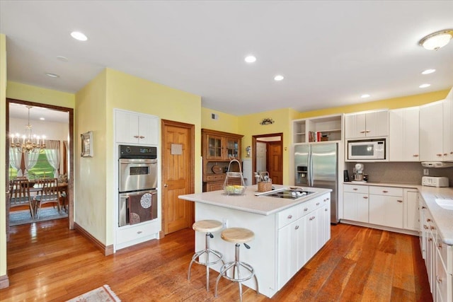 1034 Rte 292, Holmes, NY 12531 - kitchen featuring appliances with stainless steel finishes, a chandelier, a kitchen island with sink, white cabinets, and recessed lighting