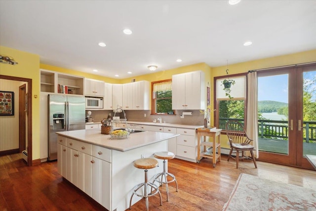 1034 Rte 292, Holmes, NY 12531 - kitchen with white microwave, stainless steel refrigerator with ice dispenser, light countertops, white cabinets, and open shelves
