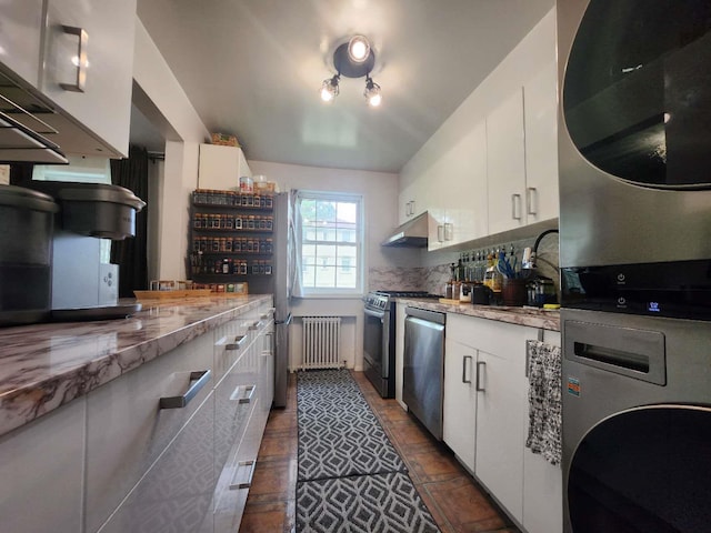 64-15 Springfield Blvd Unit A, Oakland Gardens, NY 11364 - kitchen featuring radiator, stacked washing machine and dryer, appliances with stainless steel finishes, under cabinet range hood, and white cabinetry