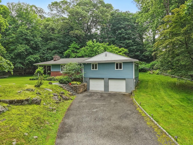 99 Furnace Dock Rd, Croton-On-Hudson, NY 10520 - view of front of home featuring asphalt driveway, a garage, a chimney, and a front lawn