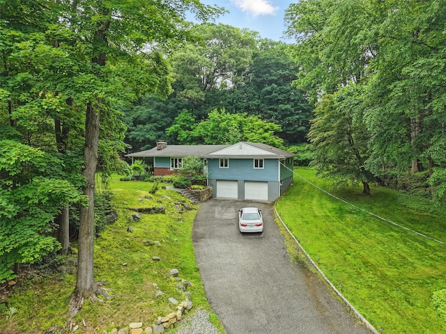99 Furnace Dock Rd, Croton-On-Hudson, NY 10520 - view of front facade featuring driveway, an attached garage, a wooded view, and a front yard
