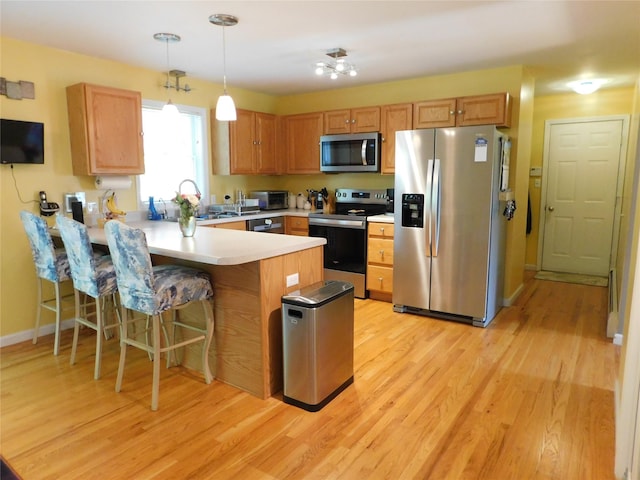133 Lattintown Rd, Newburgh, NY 12550 - kitchen featuring appliances with stainless steel finishes, a peninsula, light countertops, and light wood finished floors