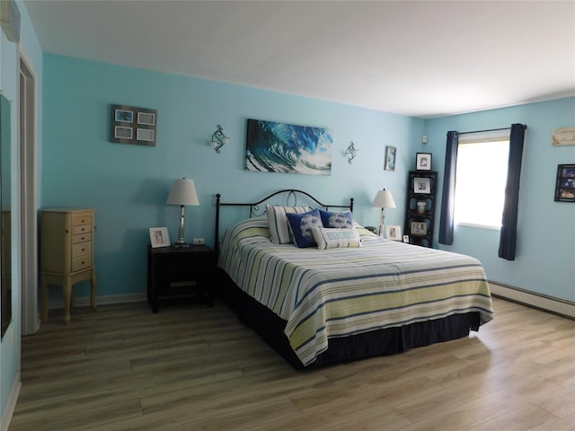 133 Lattintown Rd, Newburgh, NY 12550 - bedroom with wood finished floors and a baseboard heating unit