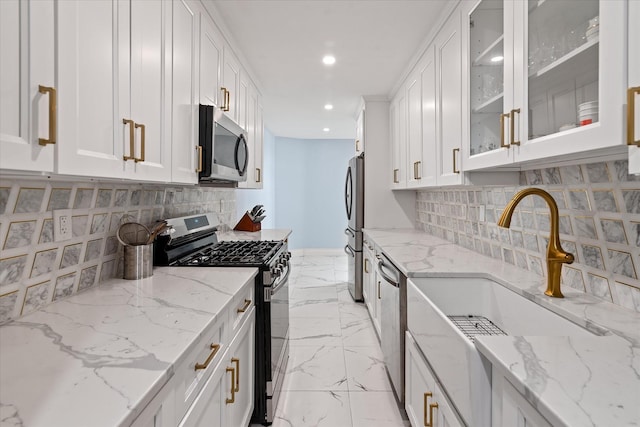 83-30 98th St Unit 5A, Woodhaven, NY 11421 - kitchen with appliances with stainless steel finishes, white cabinetry, recessed lighting, tasteful backsplash, and glass insert cabinets