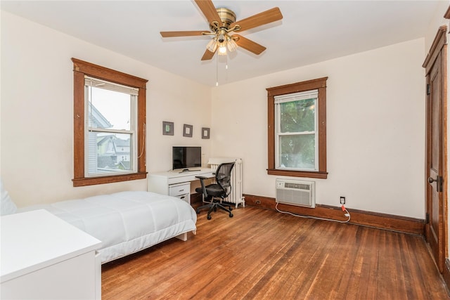 453 Marlborough Rd, Yonkers, NY 10701 - bedroom featuring wood finished floors, an AC wall unit, multiple windows, and an office area