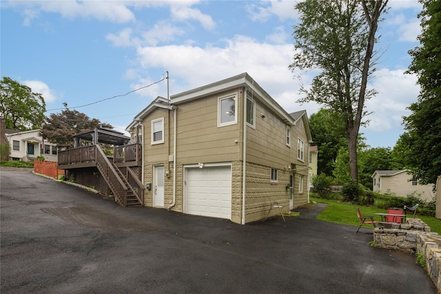 33 Hollowbrook Ct N, Cortlandt Manor, NY 10567 - view of side of home featuring stairway, driveway, a wooden deck, and an attached garage