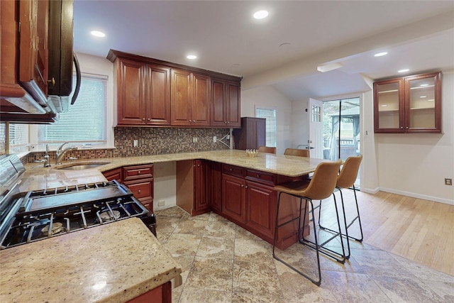 33 Hollowbrook Ct N, Cortlandt Manor, NY 10567 - kitchen with a peninsula, a kitchen bar, tasteful backsplash, light stone countertops, and recessed lighting