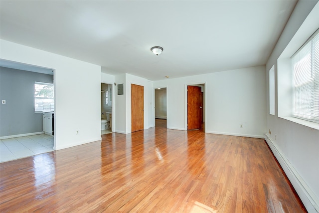 39-32 54th St, Woodside, NY 11377 - unfurnished room featuring a baseboard heating unit, light wood-style floors, and baseboards