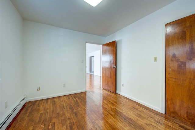 39-32 54th St, Woodside, NY 11377 - spare room with a baseboard heating unit, wood finished floors, and baseboards