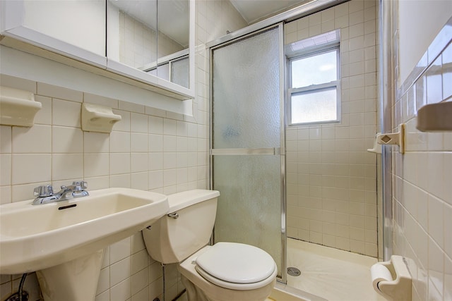 39-32 54th St, Woodside, NY 11377 - bathroom featuring tile walls, toilet, a stall shower, a sink, and tasteful backsplash