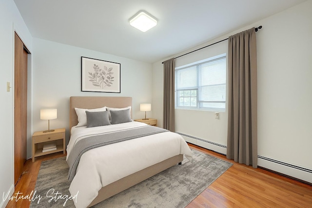 39-32 54th St, Woodside, NY 11377 - bedroom with light wood-type flooring and a baseboard heating unit
