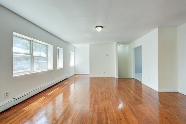 39-32 54th St, Woodside, NY 11377 - empty room with a baseboard heating unit, wood finished floors, and baseboards