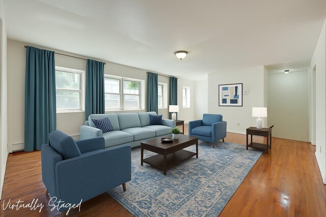 39-32 54th St, Woodside, NY 11377 - living area featuring wood finished floors and a baseboard heating unit