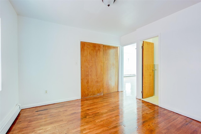 39-32 54th St, Woodside, NY 11377 - unfurnished room with a baseboard heating unit, light wood-style floors, and baseboards