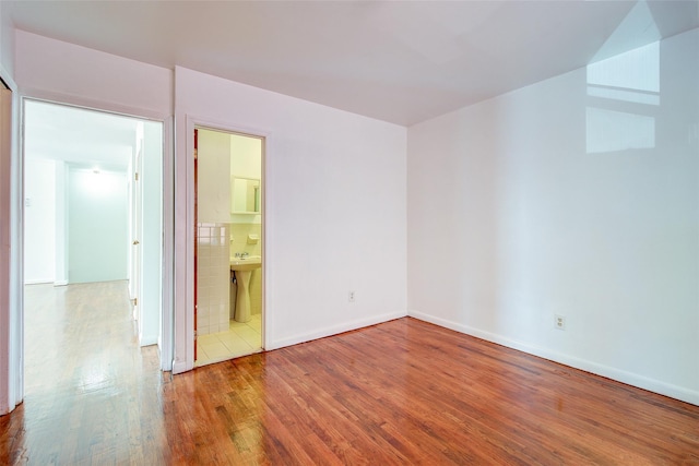 39-32 54th St, Woodside, NY 11377 - unfurnished bedroom featuring wood finished floors, baseboards, a sink, and ensuite bathroom