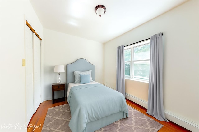 39-32 54th St, Woodside, NY 11377 - bedroom featuring a baseboard heating unit, wood finished floors, and a closet