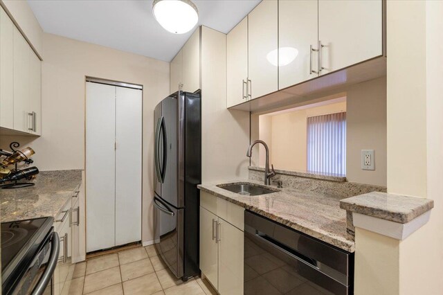 615 Broadway Unit 85, Amityville, NY 11701 - kitchen with black appliances, light stone counters, white cabinets, and light tile patterned floors