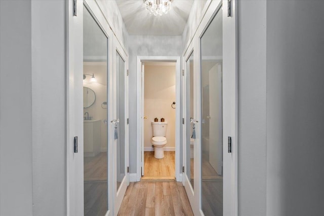 615 Broadway Unit 85, Amityville, NY 11701 - hall with light wood-style flooring and a chandelier