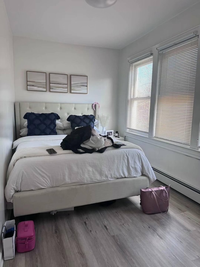125-03 13th Ave, College Point, NY 11356 - bedroom featuring a baseboard radiator and wood finished floors