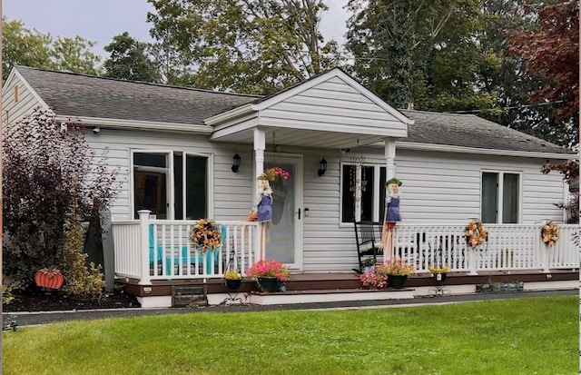 115 Dahlia Dr, Mastic Beach, NY 11951 - bungalow featuring covered porch, a front lawn, and a shingled roof