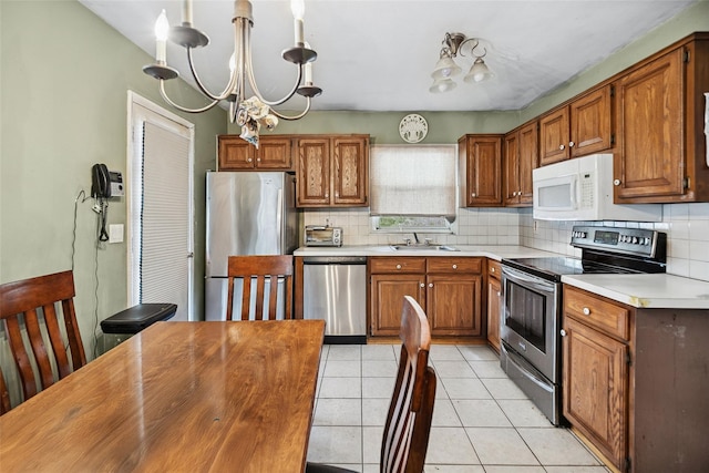 10 Marlan Ct, Smithtown, NY 11787 - kitchen featuring stainless steel appliances, light countertops, tasteful backsplash, and brown cabinets