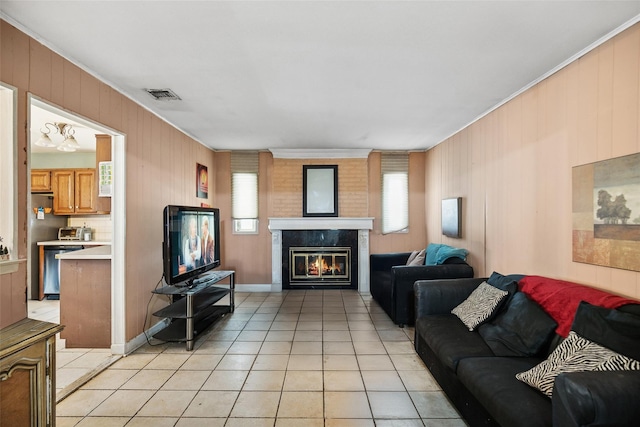 10 Marlan Ct, Smithtown, NY 11787 - living room with light tile patterned flooring, crown molding, a glass covered fireplace, and wood walls