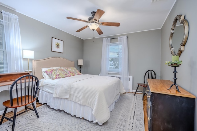10 Bradish Ln, Babylon, NY 11702 - bedroom with radiator heating unit, light wood-style floors, and ceiling fan