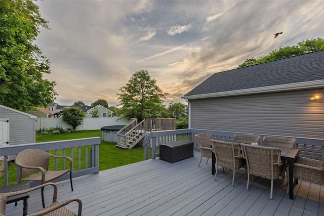 10 Bradish Ln, Babylon, NY 11702 - deck at dusk featuring a storage unit, a fenced backyard, and outdoor dining space