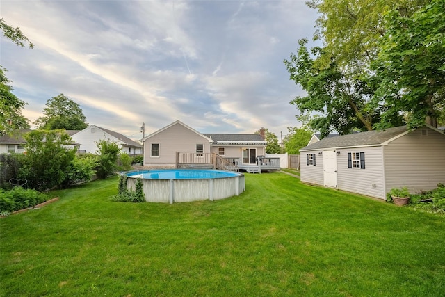 10 Bradish Ln, Babylon, NY 11702 - view of green lawn with an outdoor pool, a wooden deck, and a storage unit