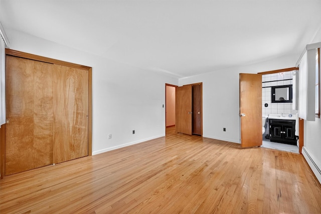 169 Rte 118, Yorktown Heights, NY 10598 - unfurnished bedroom featuring light wood-type flooring, baseboard heating, and ensuite bathroom