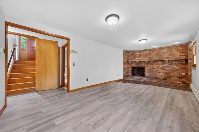 169 Rte 118, Yorktown Heights, NY 10598 - unfurnished living room with wood finished floors, a brick fireplace, stairs, and brick wall