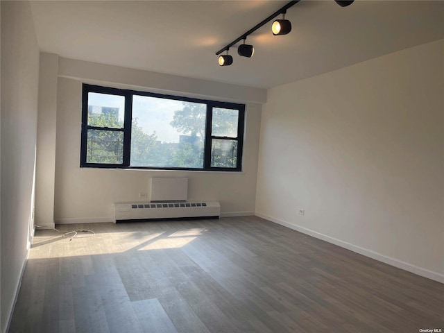 83-60 118th St Unit 7K, Kew Gardens, NY 11415 - spare room with a baseboard heating unit, wood finished floors, and track lighting