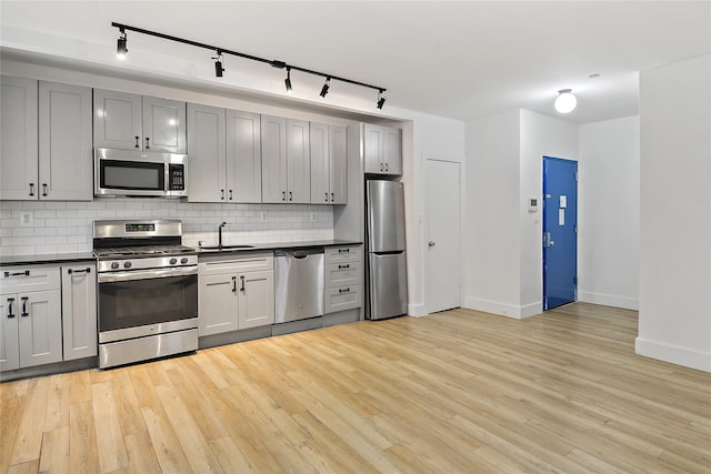 1180 Grant Ave, Bronx, NY 10456 - kitchen featuring stainless steel appliances, rail lighting, dark countertops, a sink, and backsplash