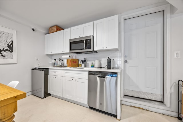 1180 Grant Ave, Bronx, NY 10456 - kitchen featuring stainless steel appliances, white cabinetry, light countertops, and backsplash
