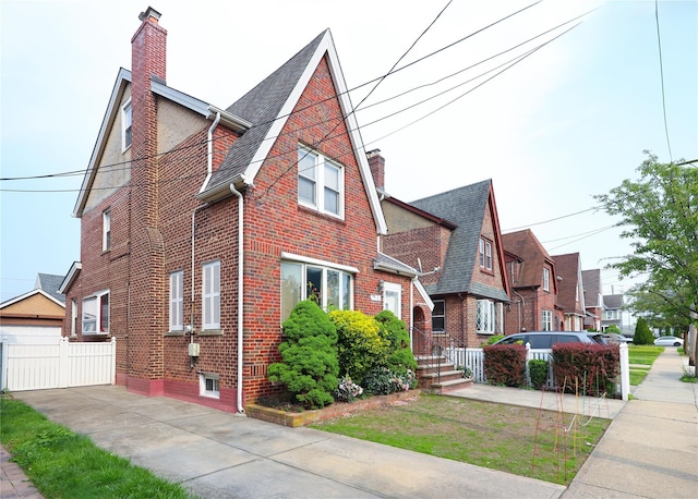 95-15 243rd St, Floral Park, NY 11001 - view of front facade featuring a chimney, brick siding, roof with shingles, and a residential view
