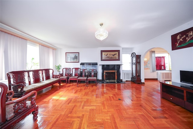 95-15 243rd St, Floral Park, NY 11001 - living room featuring arched walkways, a fireplace, a chandelier, and radiator