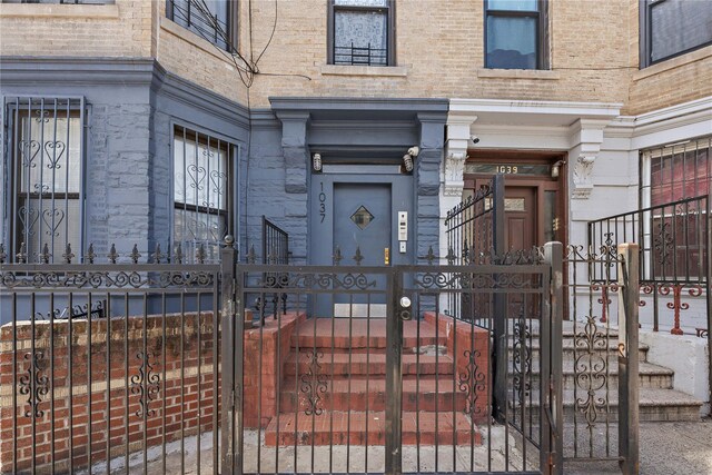1037 College Ave, Bronx, NY 10456 - view of exterior entry featuring a gate, brick siding, and stone siding